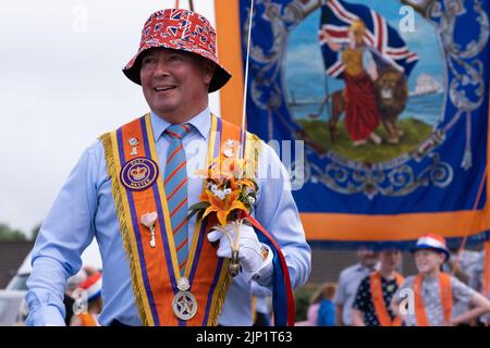 Ballymena, Großbritannien. 12. Juli 2022. Orange Order-Mitglied trägt einen Union Jack-Sonnenhut mit zeremoniellem Schwert und genießt die Rückreise der Stockfoto