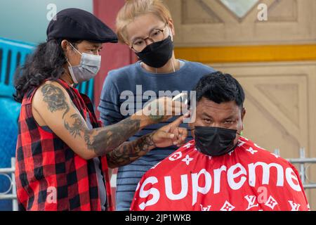 HUA HIN, THAILAND - 23. MÄRZ 2022 : Ein Mann, der einen Haarschnitt im Freien auf der Straße in der Nähe des Bahnhofs hat. Stockfoto