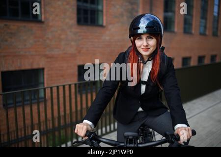 Porträt einer Geschäftsfrau, die Pendlerin auf dem Weg zur Arbeit mit einem Fahrrad, einem nachhaltigen Lifestyle-Konzept. Stockfoto