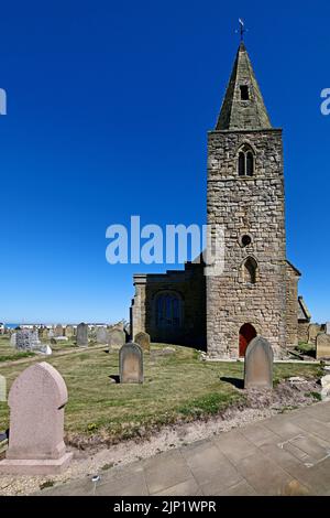 Newbiggin am Meer Northumberland schönes Küstendorf mit St. Batholomews Kirche aus dem 13.. Jahrhundert vor einem tiefblauen Sommerhimmel Stockfoto