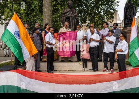 London, Großbritannien. 15. August 2022. Mitglieder der britischen indischen Gemeinschaft stehen vor der Statue von Mahatma Gandhi auf dem Parliament Square, um den 75.. Jahrestag der Unabhängigkeit Indiens am 15. August 1947 vom britischen Raj zu feiern. Kredit. Kredit: amer ghazzal/Alamy Live Nachrichten Stockfoto