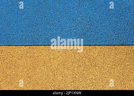 Ukrainische Symbole. Ansicht der gelb-blauen Flagge der Ukraine. Gummiboden Hintergrund, Textur, Hintergrund. Entlastungsfläche. Neue granulare Gummibeschichtung Stockfoto