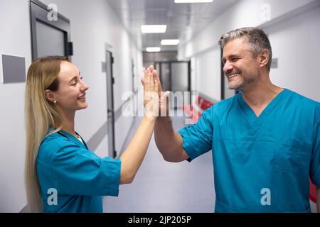 Zwei smilling und glückliche Ärzte geben einander hohe fünf Stockfoto