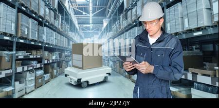 Lagerverwalter mit digitalem Tablet steuert Roboter mit einem Paket. Unbemanntes Lieferkonzept Stockfoto