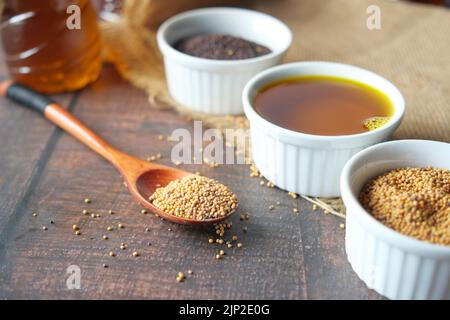 Senfölkerne auf einem Löffel auf dem Tisch Stockfoto