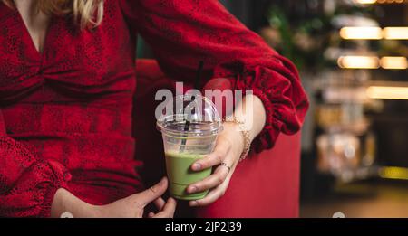 Nahaufnahme, grünes Getränk Eis Matcha Latte auf einem verschwommenen Hintergrund in einem Café. Stockfoto
