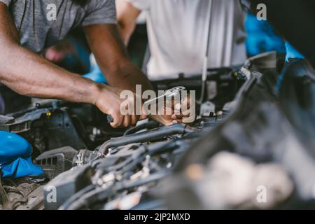 Nahaufnahme Mechaniker Hand mit Werkzeug fix Service Auto Motoröl im Motorraum in Auto Garace ersetzen Stockfoto