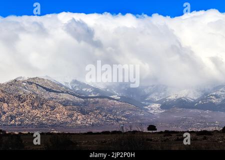 Berglandschaft von Madrid, Navacerrada. Blick aus der Ferne mit großen weißen und grauen Wolken, die den Berghang hinunter kommen. Europa. Stockfoto