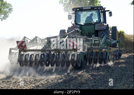 Deutschland, Landwirtschaft, Pflugloser Anbau / DEUTSCHLAND, Schleswig Holstein, Holtsee, Harzhof praktiziert seit 30 Jahren pfluglosen Ackerbau, Flachgrubber Kerner Stratos 500 am John Deere Traktor Stockfoto