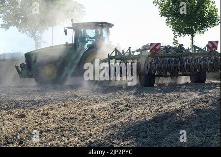 Deutschland, Landwirtschaft, Pflugloser Anbau / DEUTSCHLAND, Schleswig Holstein, Holtsee, Harzhof praktiziert seit 30 Jahren pfluglosen Ackerbau, Flachgrubber Kerner Stratos 500 am John Deere Traktor Stockfoto