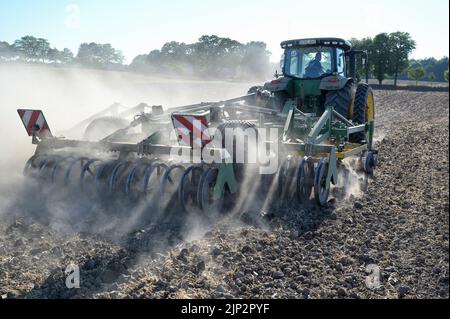 Deutschland, Landwirtschaft, Pflugloser Anbau / DEUTSCHLAND, Schleswig Holstein, Holtsee, Harzhof praktiziert seit 30 Jahren pfluglosen Ackerbau, Flachgrubber Kerner Stratos 500 am John Deere Traktor Stockfoto