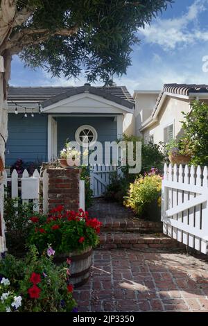 Charmantes Strandhäuschen mit einem Zaun und einem gemauerten Gehweg Stockfoto