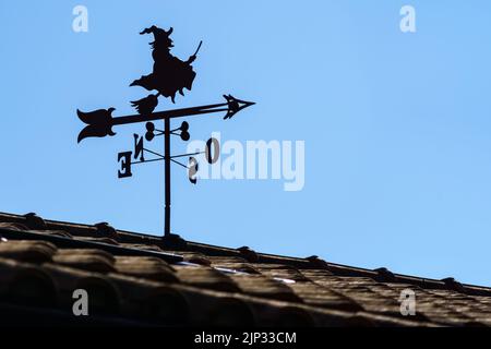 Flügel auf dem Dach des Hauses im Freien mit Hexe und Pfeil, die Richtung des Windes zeigen. Spanien. Wettervane. Stockfoto