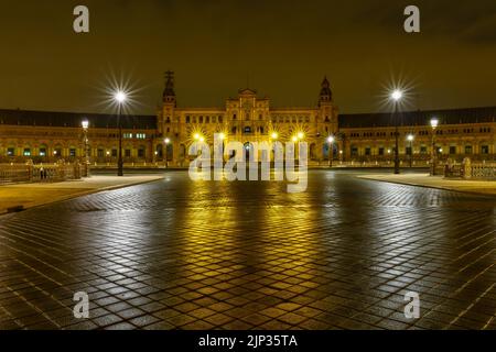 Plaza de España in Sevilla, Nachtszene nach Regen mit Langzeitbelichtung Foto und Reflexionen von Lichtern im Wasser und gepflasterten Straßen. Andalusien. Stockfoto