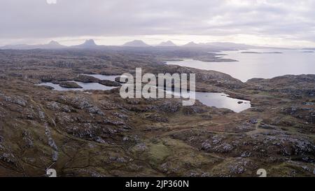 Einige der ältesten Felsen der Welt - Lewisian und Scourian Gneiss. Oberhalb von Clachtoll mit Blick auf Suilven und andere Berge von Assynt und Coigach Stockfoto