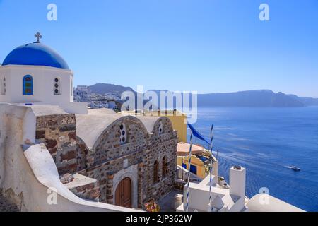 Stadt Oia auf Santorin, Griechenland. Traditionelle und berühmte Häuser und Kirchen mit blauen Kuppeln über die Caldera, Ägäis Stockfoto