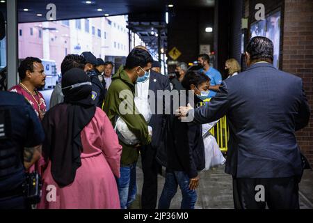 New York, USA, 15/08/2022, Asylsuchende verlassen den Bus. Ein Bus mit 52 Asylbewerbern aus Texas kam in Port Authority an. Nach Angaben von Kommissar Manuel Castro vom Büro des Bürgermeisters für Einwanderungsfragen, taten zwei von drei Bussen, die Texas verließen und anreisten, dies nicht. Der kommissar schätzt, dass etwa 120 Migranten, die nach New York City kommen sollen, unterwegs die Busse verlassen haben. Viele der Asylbewerber waren hungrig und krank, wurden Berichten zufolge gezwungen, ihre Rechte unter Druck abzuzeichnen und wurden entweder von staatlichen Strafverfolgungsbehörden oder privater Sicherheit begleitet. Stockfoto