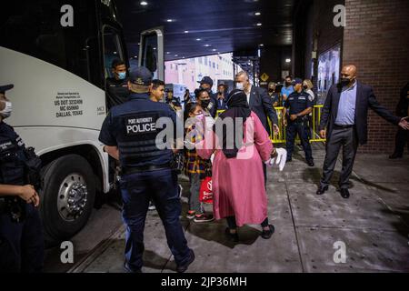 New York, USA, 15/08/2022, Asylsuchende verlassen den Bus. Ein Bus mit 52 Asylbewerbern aus Texas kam in Port Authority an. Nach Angaben von Kommissar Manuel Castro vom Büro des Bürgermeisters für Einwanderungsfragen, taten zwei von drei Bussen, die Texas verließen und anreisten, dies nicht. Der kommissar schätzt, dass etwa 120 Migranten, die nach New York City kommen sollen, unterwegs die Busse verlassen haben. Viele der Asylbewerber waren hungrig und krank, wurden Berichten zufolge gezwungen, ihre Rechte unter Druck abzuzeichnen und wurden entweder von staatlichen Strafverfolgungsbehörden oder privater Sicherheit begleitet. Stockfoto