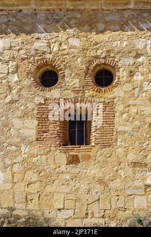 Ähnlichkeit des Gesichts in einer alten Steinhausfassade, Augen und Mund. Pedraza, Segovia. spanien. Stockfoto