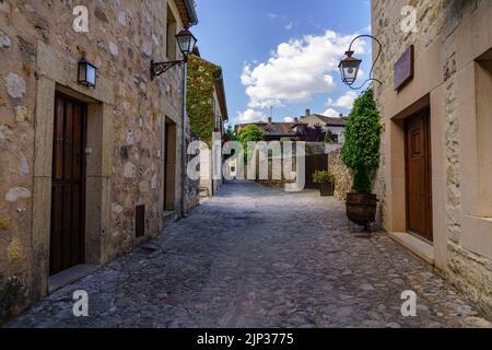 Mittelalterliche Altstadt mit Steinhäusern, alten Türen und Fenstern, gepflasterten Straßen und malerischer Atmosphäre. Pedraza, Segovia, Spanien, Europa. Stockfoto