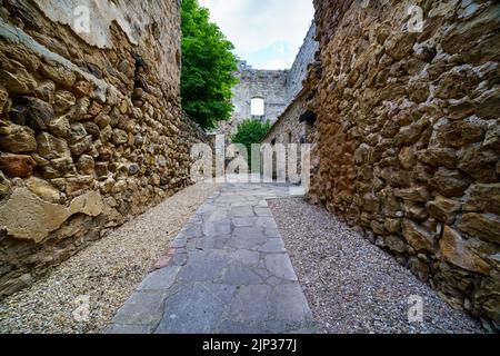 Burg Pedraza in Segovia. Alter mittelalterlicher Palast der Ritter aus Stein. Festung mit inneren Steinstraßen, grünen Pflanzen, Bögen und Tunneln. Spanien Stockfoto
