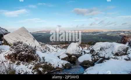 Landschaften in Großbritannien: Schnee an der berühmten Touristenattraktion Ilkley Moor mit verschneiten Felsen in der Nähe von Backstone Beck, West Yorkshire, England, Großbritannien Stockfoto