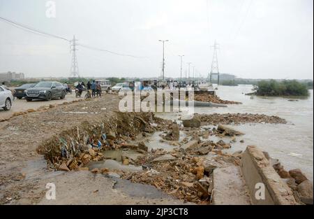 Blick auf die Zerstörung der Korangi Crossing Road aufgrund von stagnierendem Regenwasser, das zu einem schlechten Kanalisationssystem führte, das Pendler und Bewohner vor Probleme stellte, nachdem die Überschwemmung am Montag, den 15. August 2022, aufgrund des starken Regenguts der Monsunsaison, am Malir Drain River in Karachi, in das Gebiet geflossen war. Stockfoto