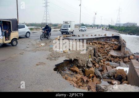 Blick auf die Zerstörung der Korangi Crossing Road aufgrund von stagnierendem Regenwasser, das zu einem schlechten Kanalisationssystem führte, das Pendler und Bewohner vor Probleme stellte, nachdem die Überschwemmung am Montag, den 15. August 2022, aufgrund des starken Regenguts der Monsunsaison, am Malir Drain River in Karachi, in das Gebiet geflossen war. Stockfoto