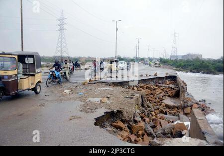 Blick auf die Zerstörung der Korangi Crossing Road aufgrund von stagnierendem Regenwasser, das zu einem schlechten Kanalisationssystem führte, das Pendler und Bewohner vor Probleme stellte, nachdem die Überschwemmung am Montag, den 15. August 2022, aufgrund des starken Regenguts der Monsunsaison, am Malir Drain River in Karachi, in das Gebiet geflossen war. Stockfoto