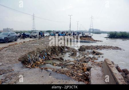 Blick auf die Zerstörung der Korangi Crossing Road aufgrund von stagnierendem Regenwasser, das zu einem schlechten Kanalisationssystem führte, das Pendler und Bewohner vor Probleme stellte, nachdem die Überschwemmung am Montag, den 15. August 2022, aufgrund des starken Regenguts der Monsunsaison, am Malir Drain River in Karachi, in das Gebiet geflossen war. Stockfoto