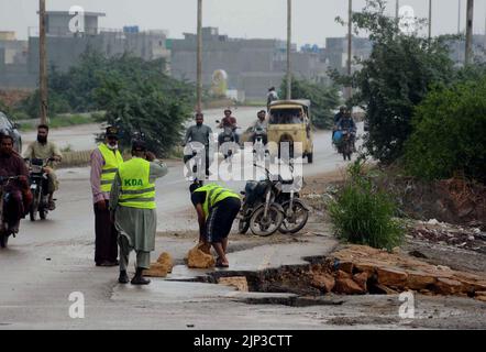 Blick auf die Zerstörung der Korangi Crossing Road aufgrund von stagnierendem Regenwasser, das zu einem schlechten Kanalisationssystem führte, das Pendler und Bewohner vor Probleme stellte, nachdem die Überschwemmung am Montag, den 15. August 2022, aufgrund des starken Regenguts der Monsunsaison, am Malir Drain River in Karachi, in das Gebiet geflossen war. Stockfoto