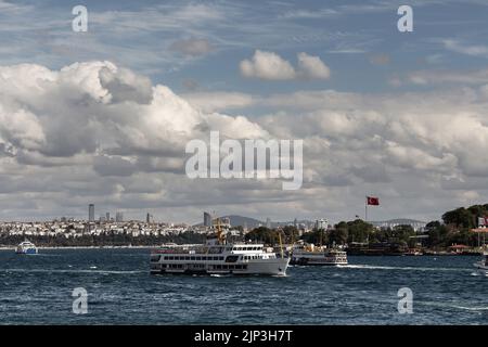 Blick auf die Fährschiffe, die vor dem Topkapi-Palast in Istanbul vorbeifahren. Die asiatische Seite ist im Hintergrund. Es ist ein sonniger Sommertag. Stockfoto