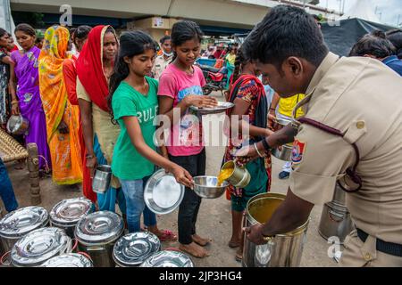 Neu-Delhi, Indien. 15. August 2022. Freiwillige der Regierung von Delhi versorgen die betroffenen Menschen an der Pusta Road in Neu-Delhi mit Nahrungsmitteln. Die Regierung von Delhi kommt zur Rettung von Menschen, die in den niedrig gelegenen Gebieten von Delhi lebten, wurden gezwungen, auf den Straßen zu leben, nachdem ihre Häuser vom überfließenden Yamuna-Fluss überflutet wurden. Kredit: SOPA Images Limited/Alamy Live Nachrichten Stockfoto