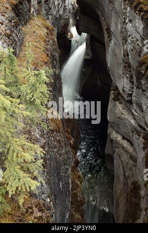 Eine Langzeitaufnahme eines strömenden Wasserfalls in den felsigen Hügeln Stockfoto