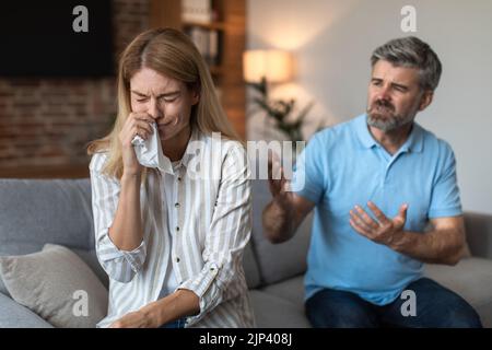 Wütend aufgeregt reifen europäischen Ehemann brüllt weinende Frau, Paar streitenden im Wohnzimmer Interieur Stockfoto