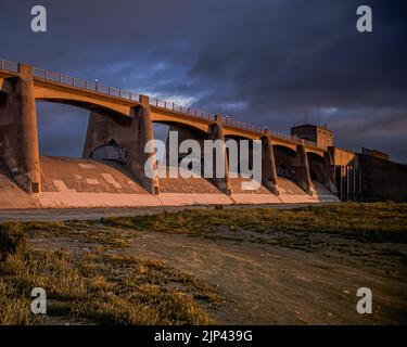 Eine Betonbrücke mit Graffiti-Wandkunst während eines wunderschönen Sonnenuntergangs Stockfoto