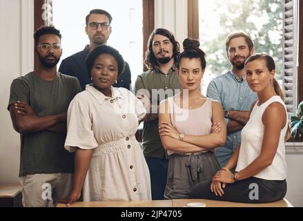 Seriöse Geschäftsleute, die mit gekreuzten Armen stehen, sehen selbstbewusst aus und zeigen Teamwork in einem Büro bei der Arbeit. Porträt von vielfältigen kreativen Stockfoto