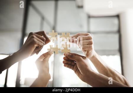 Geschäftsleute haben ein Puzzle, das Lösungen, Problemlösungen und Teamwork zeigt. Intelligente Gruppen- oder Teamaktivität, die ein Aufgabenprojekt abschließt oder beendet Stockfoto