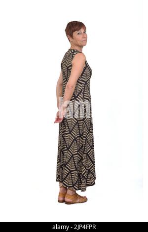Vollständige Rückansicht einer Frau mittleren Alters, die ein Kleid trug und die Kamera auf weißem Hintergrund ernst ansah Stockfoto