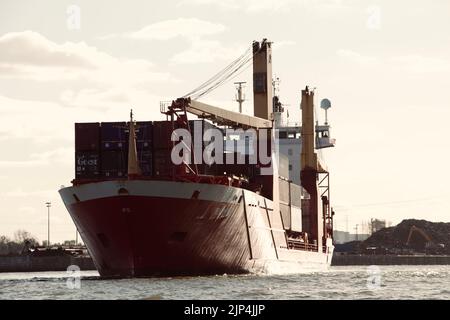 Ein großes Containerschiff, das den Hamburger Hafen verlässt Stockfoto