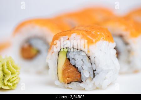 Sushi-Rollen auf Platte, heller Hintergrund. Serviert mit Wasabi und Ingwer. Verschiedene japanische Sushi. Traditionelles Essen. Stockfoto