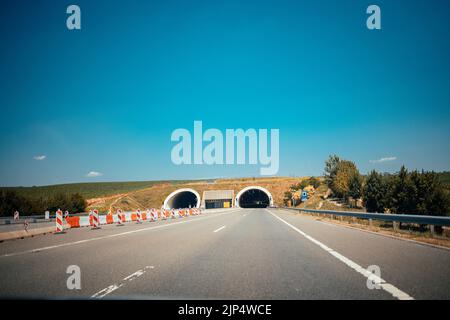 Zwei parallele Autobahnen mit zwei Tunneln unter blauem Himmel Stockfoto