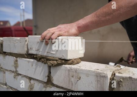 Baumeister Maurer baut Wände aus Ziegeln, Nahaufnahme Stockfoto