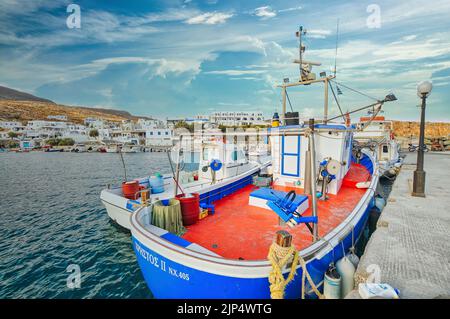 Eine malerische Aussicht auf Boote im Hafen von Folegandros in Karavostasi mit weißen Gebäuden im Hintergrund Stockfoto