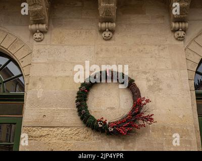 An der Wand hängt ein Weihnachtskranz Stockfoto