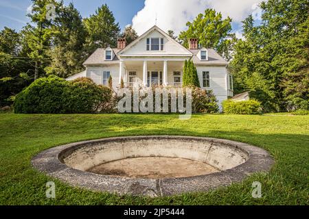 Blick auf Carl Sandburg Haus mit Blick auf einen leeren Zementbrunnen im grünen Gras an einem Sommertag. Stockfoto