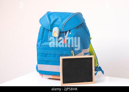 Schulrucksack auf dem Tisch. Vorbereitung auf die Schule Stockfoto