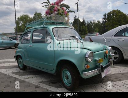 Der legendäre Auto-Supermini Zastava 750 (Fiat 600), der von 1955 bis 1985 produziert wurde, parkte vor dem Blumengeschäft, geschmückt mit Blumen Stockfoto