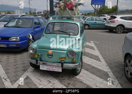 Der legendäre Auto-Supermini Zastava 750 (Fiat 600), der von 1955 bis 1985 produziert wurde, parkte vor dem Blumengeschäft, geschmückt mit Blumen Stockfoto