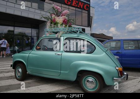 Der legendäre Auto-Supermini Zastava 750 (Fiat 600), der von 1955 bis 1985 produziert wurde, parkte vor dem Blumengeschäft, geschmückt mit Blumen Stockfoto